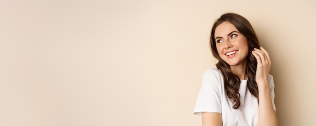 Close up portrait of coquettish beautiful girl gazing silly gently smiling and giggling posing flirt