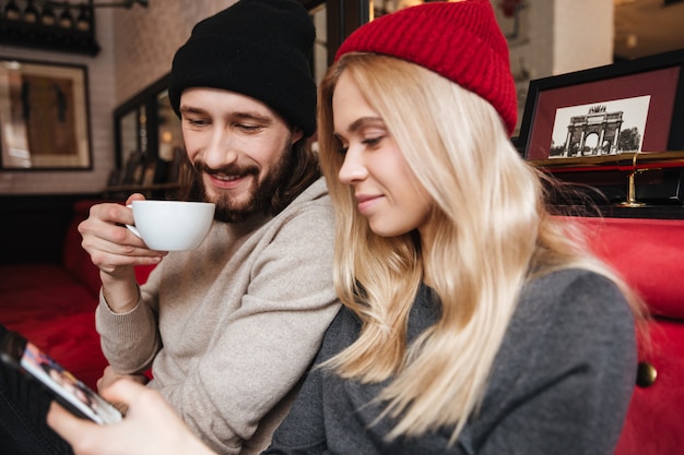 Close up portrait of Couple looking at phone in cafe