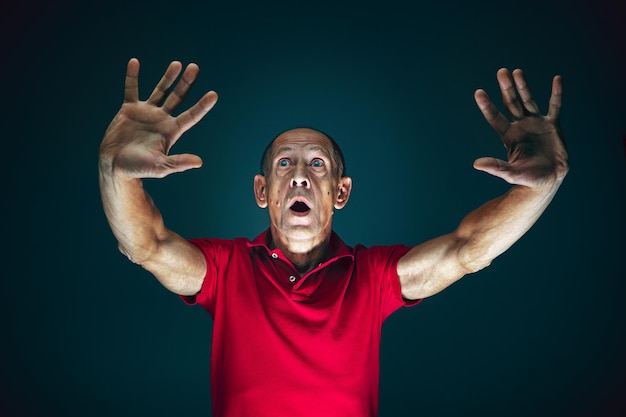 Close up portrait of crazy scared and shocked man isolated on dark