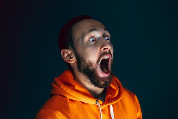 Free photo close up portrait of crazy scared and shocked man isolated on dark