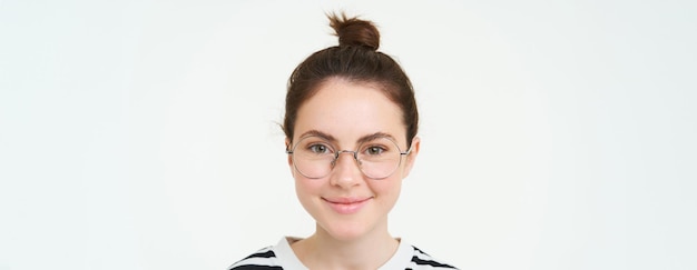 Free photo close up portrait of cute young woman in glasses looking at camera and smiling trying on new