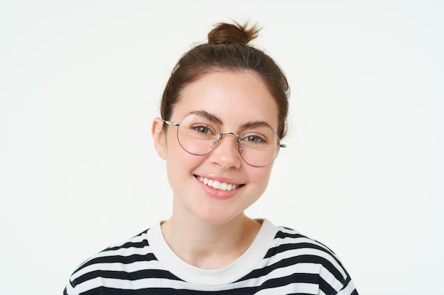 Free photo close up portrait of cute young woman in glasses looking at camera and smiling trying on new