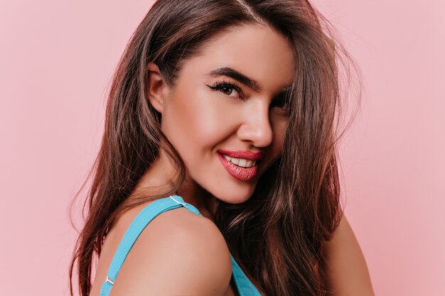 Close-up portrait of enchanting smiling girl isolated on pink space