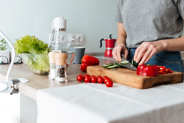 Foto gratuita chiuda sul ritratto delle mani femminili che affettano le verdure