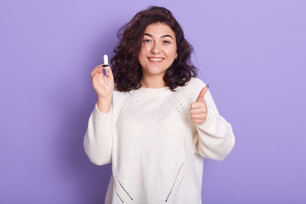 Close up portrait of female holds tampon over lilac