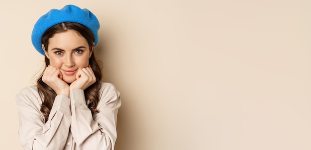 Close up portrait of feminine young woman in trendy french hat posing cute and romantic making silly