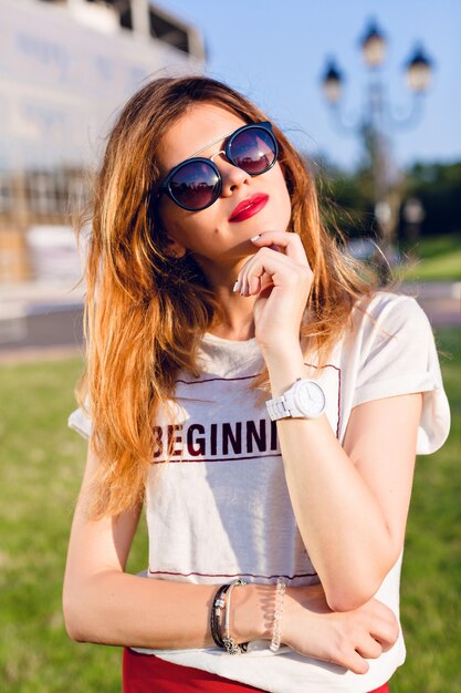 Close-up portrait of a girl with ombre hair holding her left hand near chin.