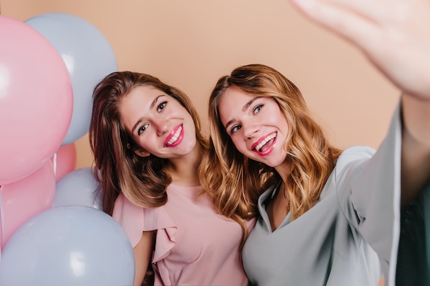 Close-up portrait of good-looking brunette woman with blue balloons