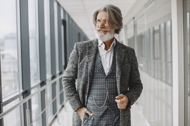 Close up portrait of grinning old-fashioned man. Elegant man at the office.