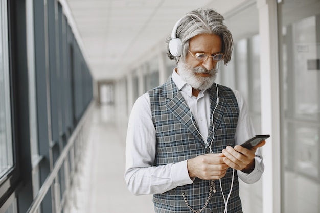 Chiuda sul ritratto dell'uomo antiquato ghignante. uomo elegante in ufficio.