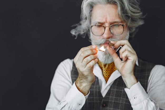 Close up portrait of grinning old-fashioned man.  Grandfather with a cigar.