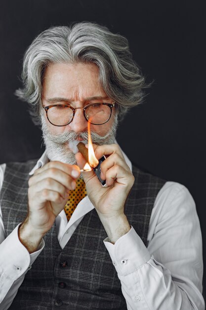 Close up portrait of grinning old-fashioned man.  Grandfather with a cigar.