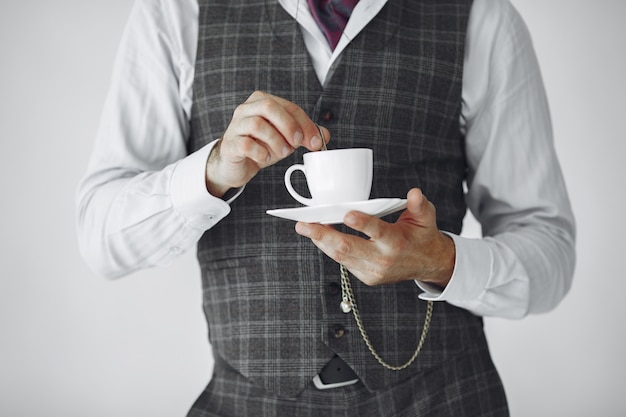 Close up portrait of grinning old-fashioned man.  Grandfather with a mug of tea.