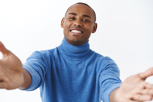 Close-up portrait of handsome, lovely, friendly-looking african american man reaching hands forward for hug, cuddling