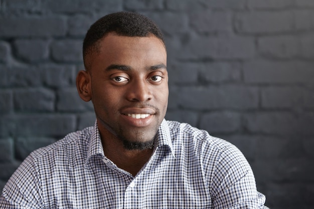 Close-up portrait of handsome young dark-skinned student or employee