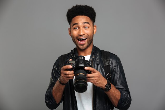 Close-up portrait of happy exited afro american man holding photocamera