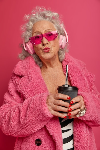 Foto gratuita chiuda sul ritratto della nonna alla moda rugosa felice che indossa collant rosa e cappotto