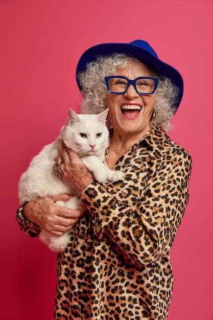 Крупным планом портрет счастливой морщинистой модной бабушки с красивой кошкой