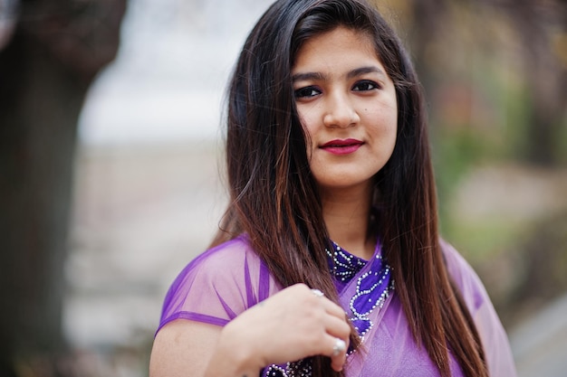 Foto gratuita ritratto ravvicinato di una ragazza indù indiana al tradizionale saree viola poste in strada