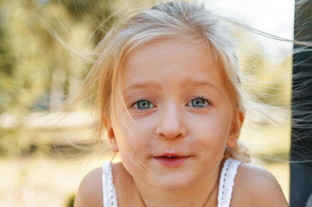 夏の日の小さなブロンドの女の子の肖像画をクローズアップ