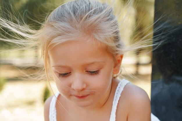 夏の日の小さなブロンドの女の子の肖像画をクローズアップ