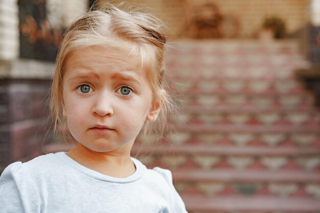 Close up portrait of a little blonde girl on a summer day