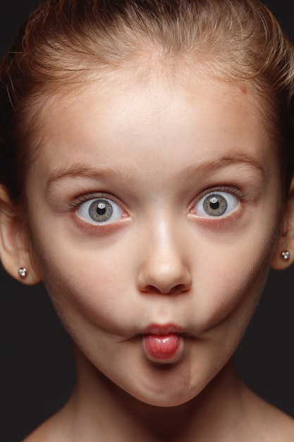 Close up portrait of little and emotional caucasian girl. Highly detail photoshoot of female model with well-kept skin and bright facial expression. Concept of human emotions. Playful gremaces.