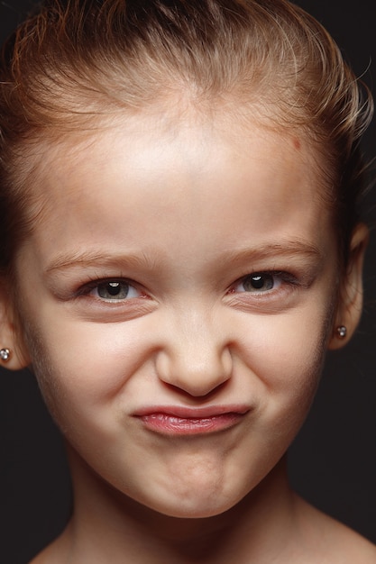 Free photo close up portrait of little and emotional caucasian girl. highly detail photoshoot of female model with well-kept skin and bright facial expression. concept of human emotions. playful gremaces.