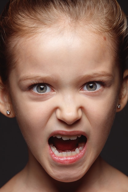 Free photo close up portrait of little and emotional caucasian girl. highly detail photoshot of female model with well-kept skin and bright facial expression. concept of human emotions. angry, agressive.