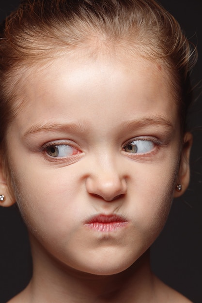 Close up portrait of little and emotional caucasian girl. Highly detail photoshot of female model with well-kept skin and bright facial expression. Concept of human emotions. Angry, gloomy.