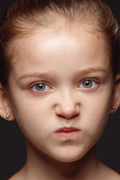 Close up portrait of little and emotional caucasian girl. Highly detail photoshot of female model with well-kept skin and bright facial expression. Concept of human emotions. Angry, gloomy.