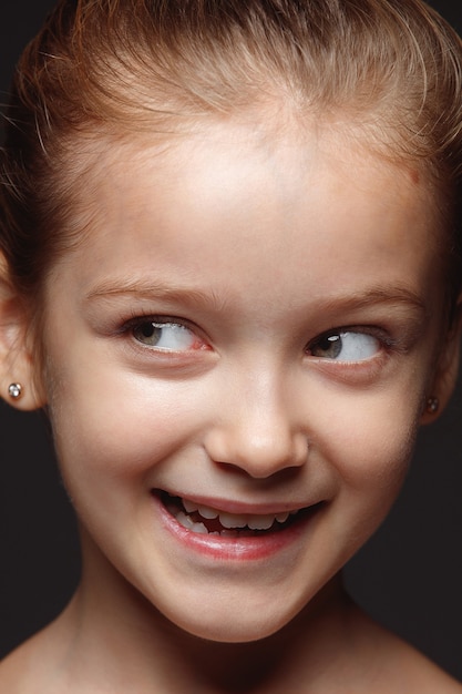 Close up portrait of little and emotional caucasian girl. Highly detail photoshot of female model with well-kept skin and bright facial expression. Concept of human emotions. Playful, looking at side.