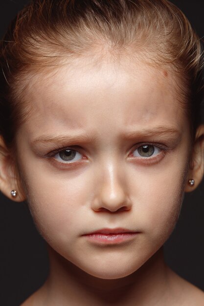 Close up portrait of little and emotional caucasian girl. Highly detail photoshot of female model with well-kept skin and bright facial expression. Concept of human emotions. Sad, upset.