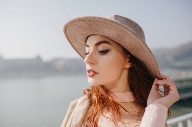 Close-up portrait of lovely ginger woman enjoying sunny weather