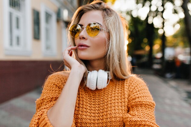 Foto gratuita ritratto del primo piano della magnifica signora con capelli biondi dritti che guarda lontano con l'espressione del viso un po 'preoccupata