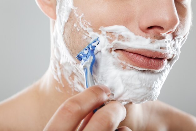 Close up portrait of a man with shaving foam on his face
