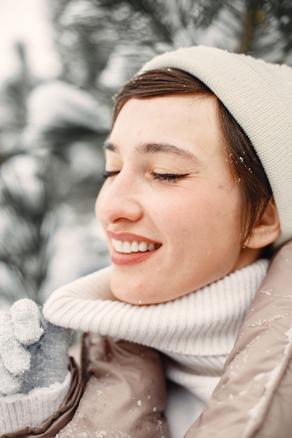Бесплатное фото Крупным планом портрет женщины в коричневой куртке в снежном парке