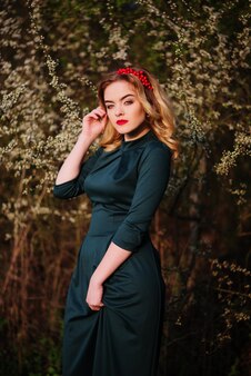 花の木​の​春​の​庭​の​緑​の​ドレス​で​容​エレガントな​ブロンド​の​女の子​の​肖像画​間近します​。