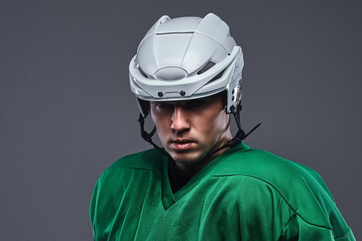 Free Photo close-up portrait of a professional hockey player in a protective sportswear and helmet. isolated on a gray background.