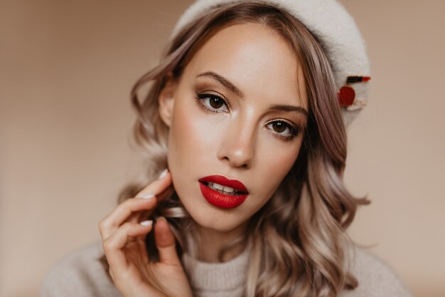 Close-up portrait of refined beautiful woman isolated on brown wall