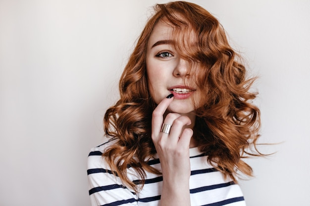 Close-up portrait of sensual european girl with ginger hair. Dreamy white lady touching her face while posing.