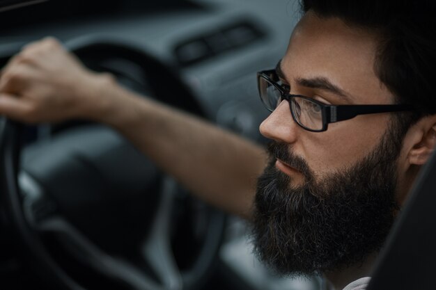 Close up portrait, serious man driving a car