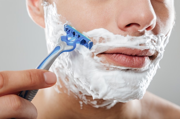 Close up portrait of a serious man with shaving foam