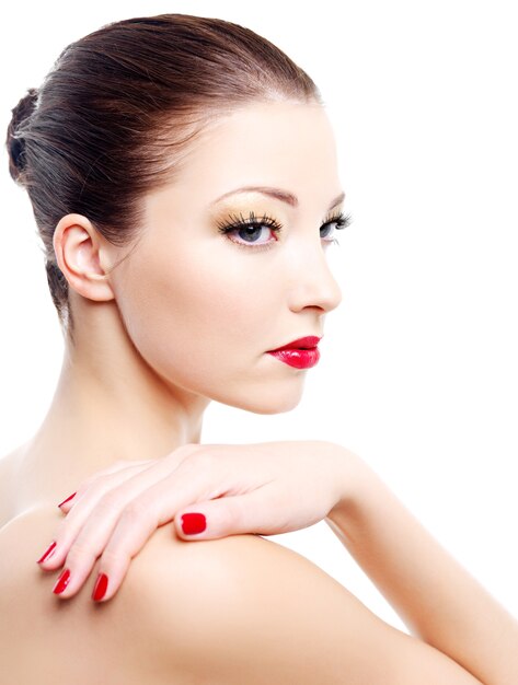 Close-up portrait of sexy caucasian young woman with golden glamour make-up and red bright manicure