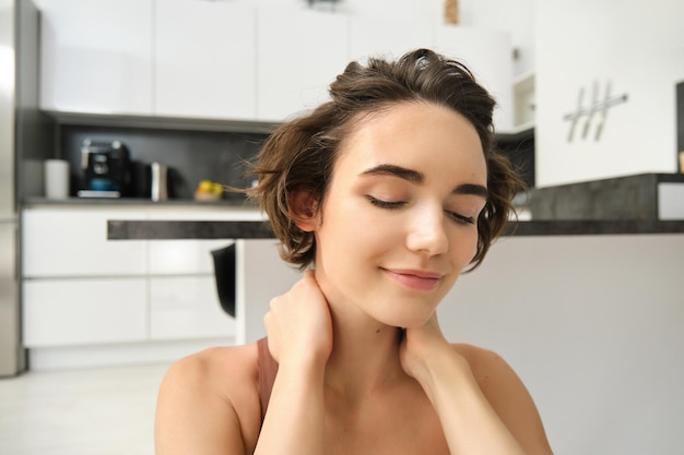 Close up portrait of sportswoman fitness woman massaging her neck warmup her body after workout doin