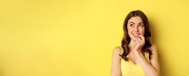 Free photo close up portrait of stylish young beautiful woman thinking yearning smth looking up and making choi