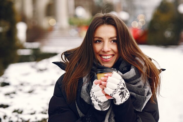 コーヒーを飲む黒いジャケットの女性のクローズアップの肖像画