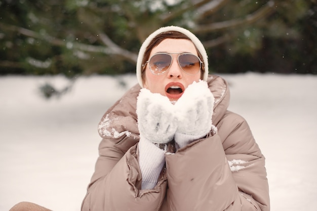 雪の公園で茶色のジャケットを着た女性のクローズアップの肖像画