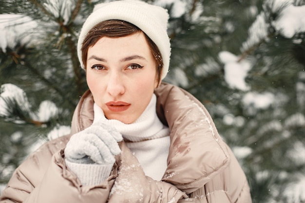 Close-up portrait of woman in brown jacket in snowy park
