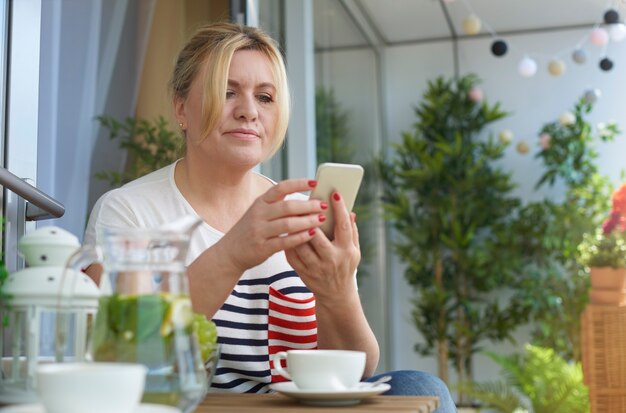 バルコニーでコーヒーを飲む女性の肖像画を閉じる